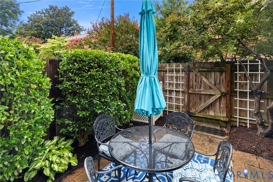 405 N Hamilton Street, #G, Richmond, VA 23221 Paved patio area featuring lush perimeter hedges, a wooden fence, and decorative trellises