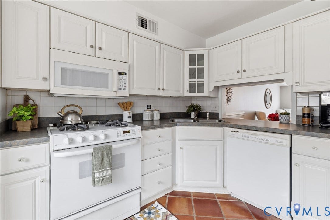 405 N Hamilton Street, #G, Richmond, VA 23221 White cabinetry with ample storage, integrated microwave, white tile backsplash, corner sink, and terra cotta-style flooring