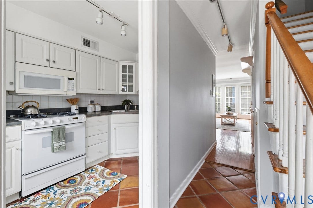 405 N Hamilton Street, #G, Richmond, VA 23221 Bright galley kitchen featuring white cabinetry with glass-front uppers, stainless steel appliances, dark countertops, and decorative tile flooring