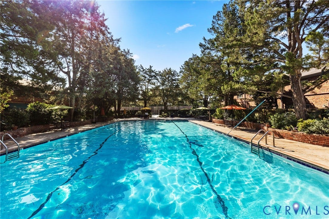 405 N Hamilton Street, #G, Richmond, VA 23221 Rectangular swimming pool with integrated lane lines and metal handrails, bordered by a brick perimeter and mature trees