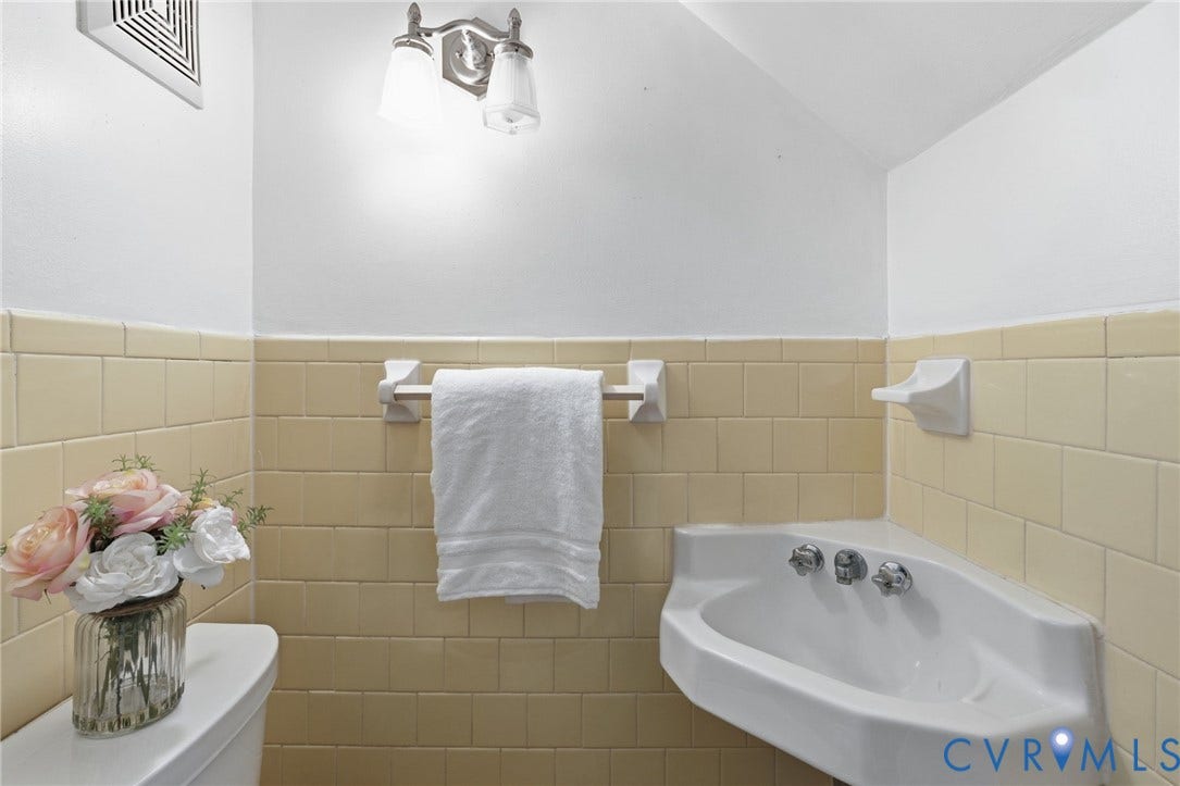 405 N Hamilton Street, #G, Richmond, VA 23221 Corner-mounted basin sink with chrome fixtures, tiled wainscoting, and a wall-mounted light fixture with two glass shades