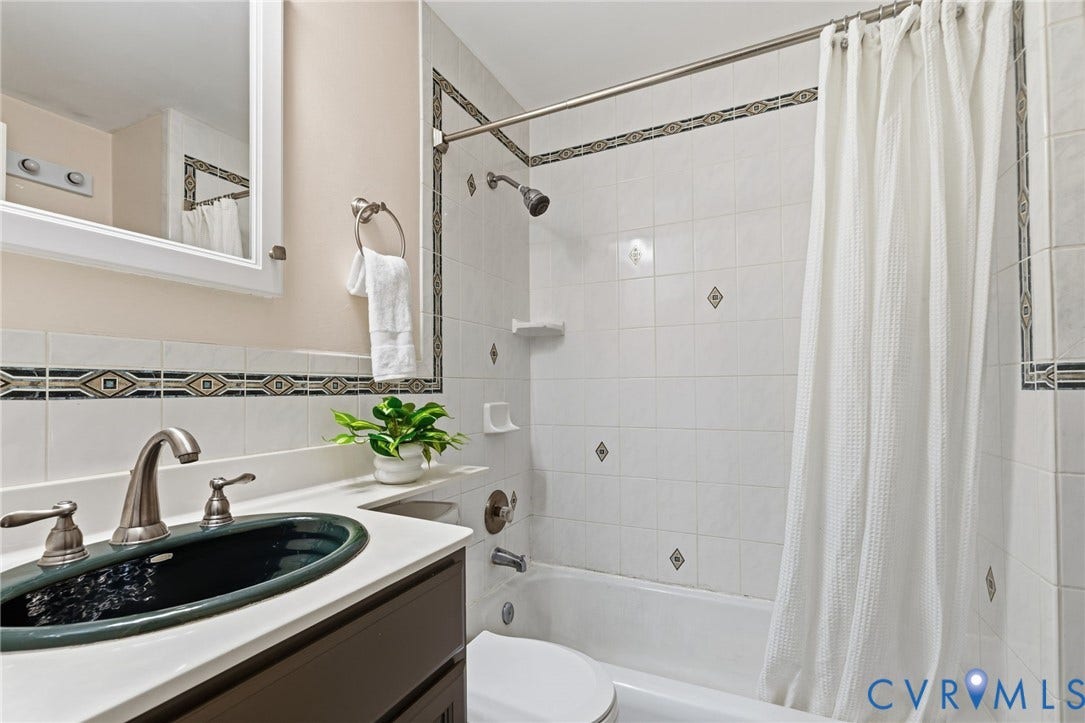 405 N Hamilton Street, #G, Richmond, VA 23221 Bathroom featuring a white subway tile surround with decorative accent tiles, a white-top vanity with an integrated sink, and brushed nickel fixtures