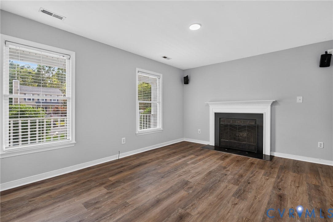 2020 Knotty Drive, Glen Allen, VA 23060 Wood-finish flooring, white trim, recessed lighting, and a fireplace with a black surround and white mantel