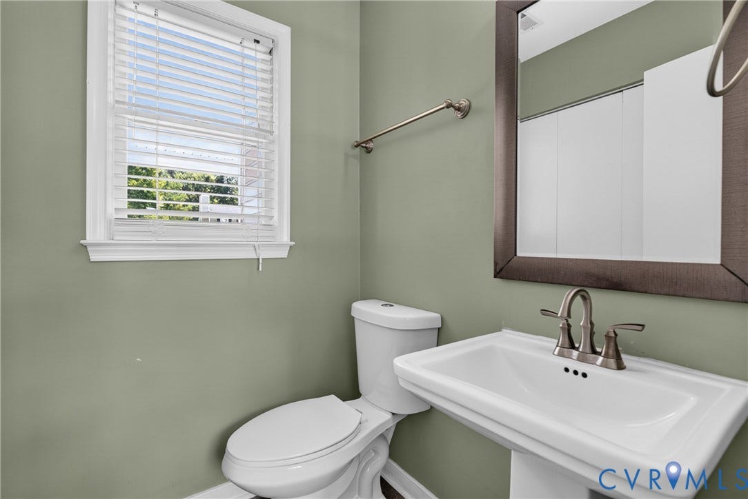 2020 Knotty Drive, Glen Allen, VA 23060 White pedestal sink with a brushed nickel faucet, a framed mirror, and a white toilet