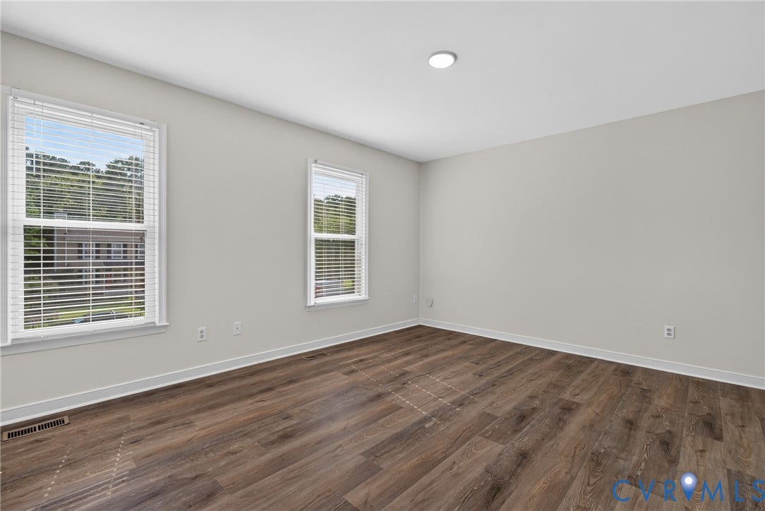 2020 Knotty Drive, Glen Allen, VA 23060 Bright, light-filled bedroom showcasing hardwood flooring, dual windows with white frames and plantation shutters, recessed ceiling lighting, and neutral wall finishes