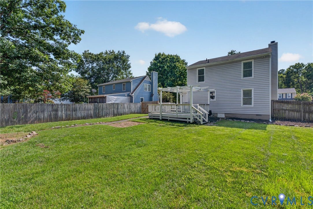 2020 Knotty Drive, Glen Allen, VA 23060 Expansive backyard featuring a manicured lawn with mature landscaping and wooden privacy fencing