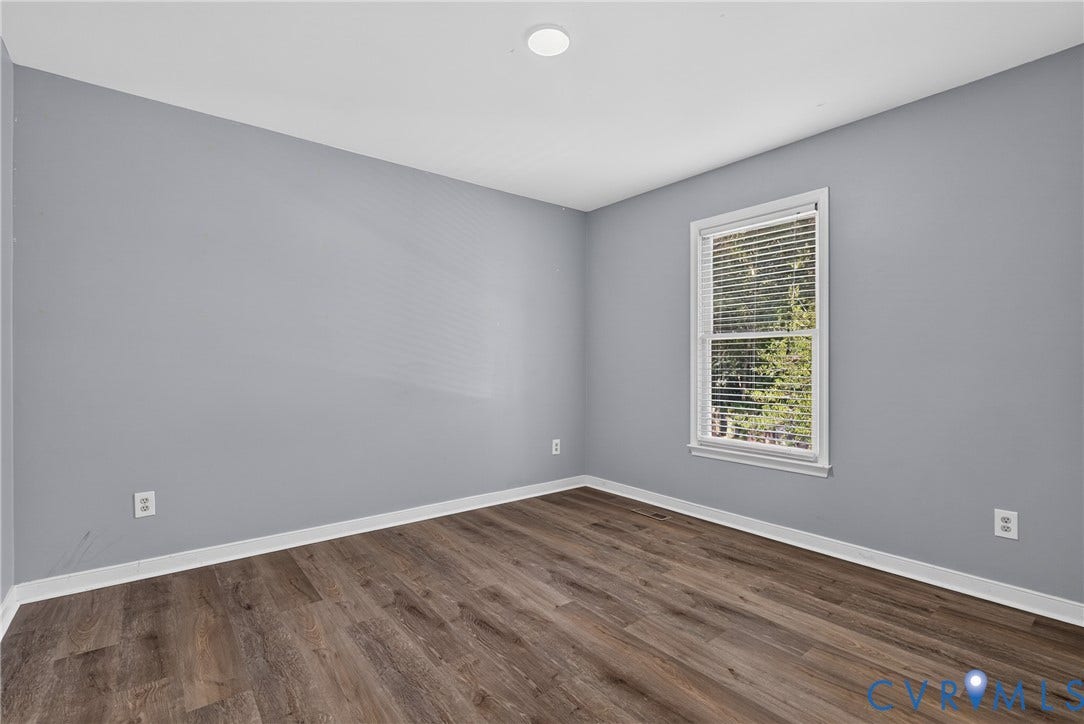 2020 Knotty Drive, Glen Allen, VA 23060 Bright corner bedroom showcasing neutral gray walls, recessed ceiling lighting, and warm wood-finish flooring