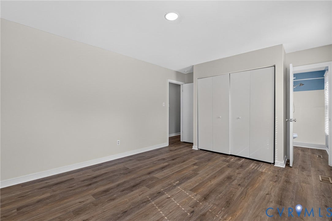 2020 Knotty Drive, Glen Allen, VA 23060 Spacious bedroom showcasing gleaming wood-finish flooring, pristine white walls, and ample natural light from recessed ceiling fixtures