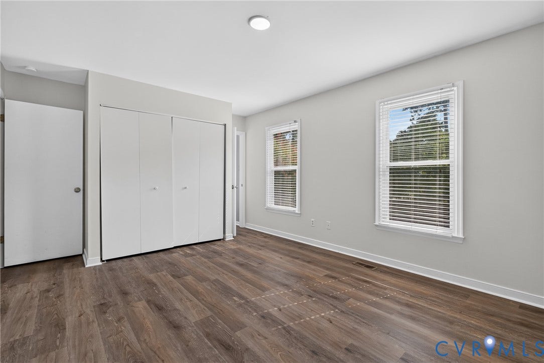 2020 Knotty Drive, Glen Allen, VA 23060 Spacious bedroom featuring gleaming wood-finish flooring, abundant natural light from dual double-hung windows with plantation shutters, and generous closet storage with white bi-fold doors