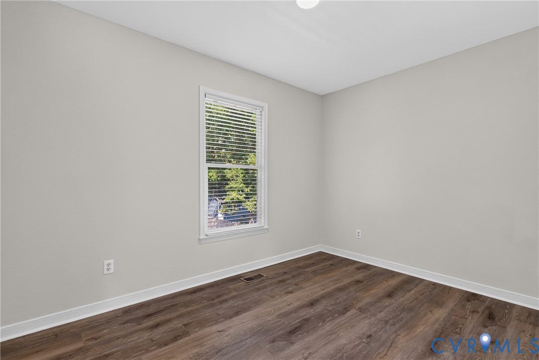 2020 Knotty Drive, Glen Allen, VA 23060 Bright, neutral bedroom with pristine drywall finishes, large double-hung window with plantation shutters providing natural light, and rich wood-finish flooring throughout