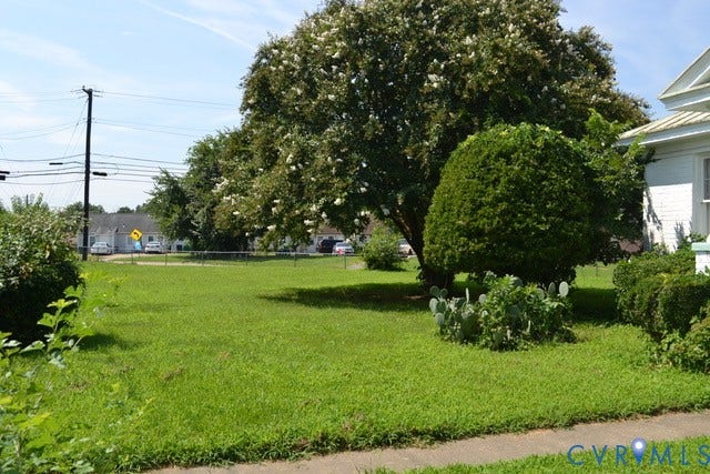 Expansive green lawn with mature trees and established plantings