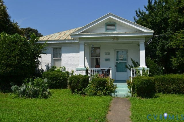 White brick exterior with a pitched roof and a front porch