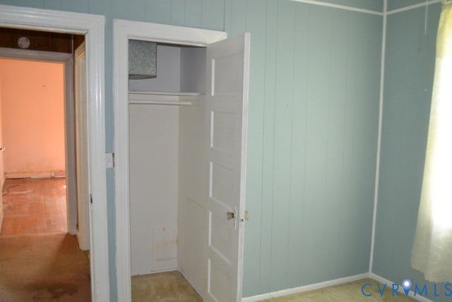 Light blue vertical plank wall paneling, white interior door, and white trim