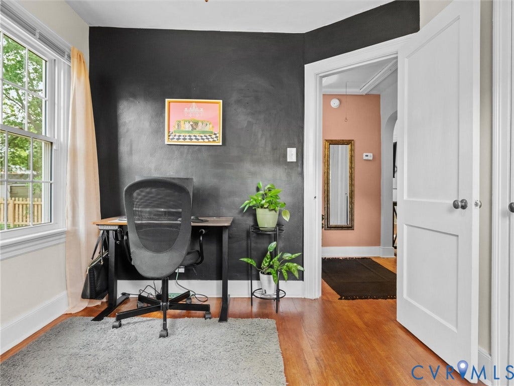 5023 E Seminary Avenue, Richmond, VA 23227 Room featuring hardwood flooring, a contrasting accent wall, and a double-hung window with privacy curtains