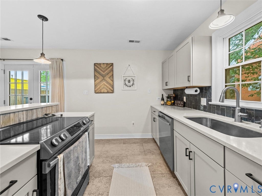 5023 E Seminary Avenue, Richmond, VA 23227 Modern kitchen featuring light cabinetry, a built-in electric range, and solid surface countertops