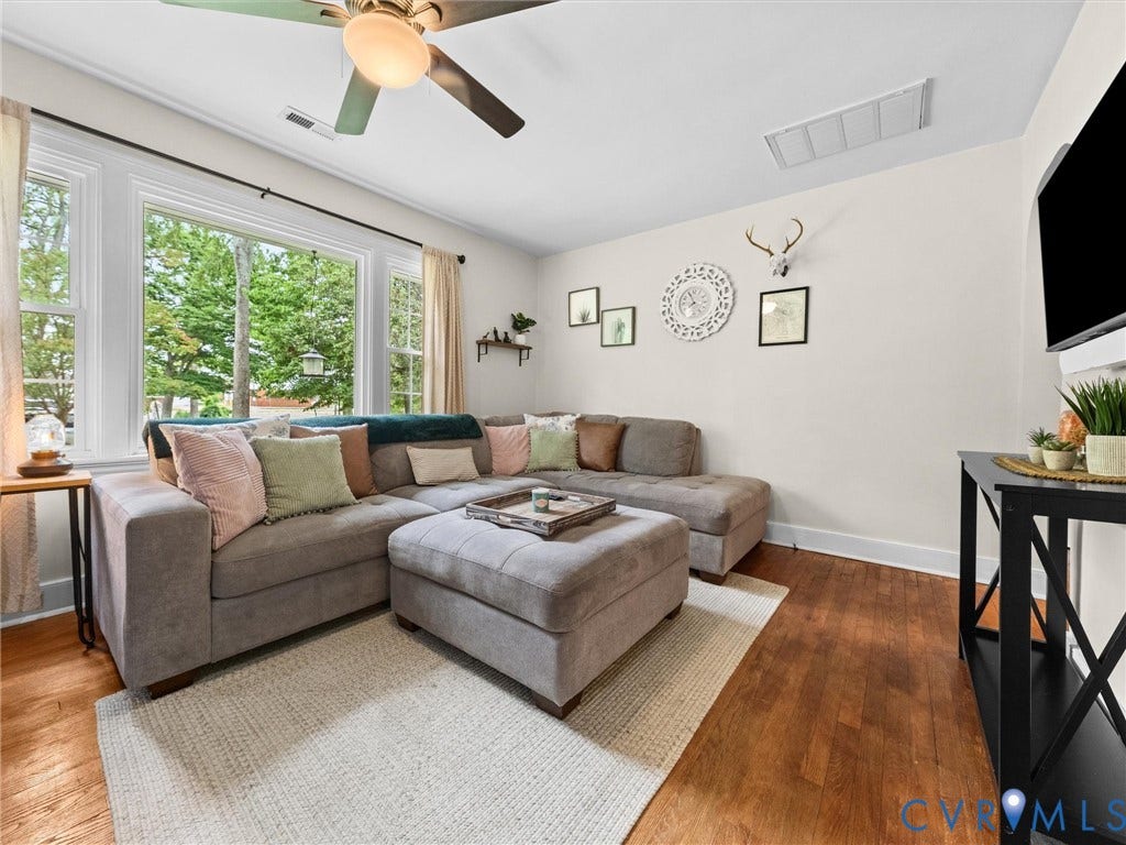 5023 E Seminary Avenue, Richmond, VA 23227 Living area featuring a large bay window, wood-finish flooring, a ceiling fan, and white baseboards