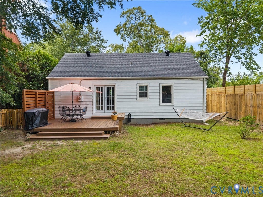 5023 E Seminary Avenue, Richmond, VA 23227 Expansive backyard featuring a multi-level wood-finish deck with privacy screening, French doors, white siding, and a wooden perimeter fence