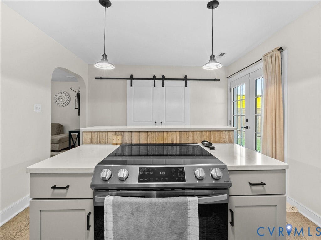 5023 E Seminary Avenue, Richmond, VA 23227 Kitchen featuring an electric range, light gray cabinetry with black hardware, and an island with a light-toned countertop