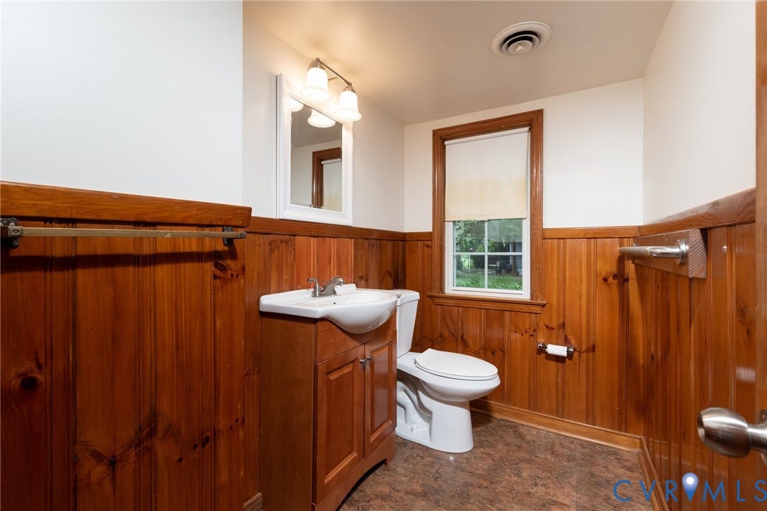 2519 Woodmont Drive, Woodmont, Chesterfield, VA 23235 Bathroom featuring wood paneling, white walls, and a window with a roller shade