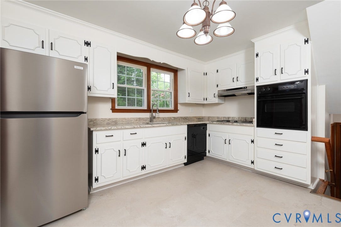 2519 Woodmont Drive, Woodmont, Chesterfield, VA 23235 Bright kitchen featuring white cabinetry with black hardware, light-toned countertops, a stainless steel refrigerator, and built-in black oven