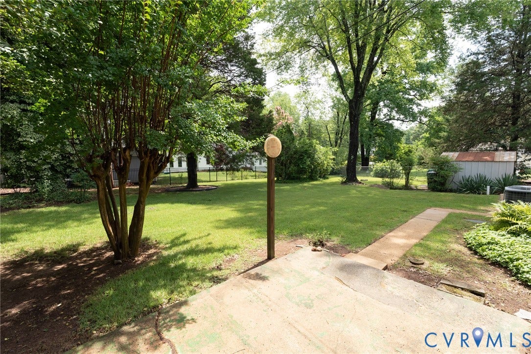 2519 Woodmont Drive, Woodmont, Chesterfield, VA 23235 Expansive backyard featuring a large concrete patio, a concrete pathway, and a mature tree providing shade