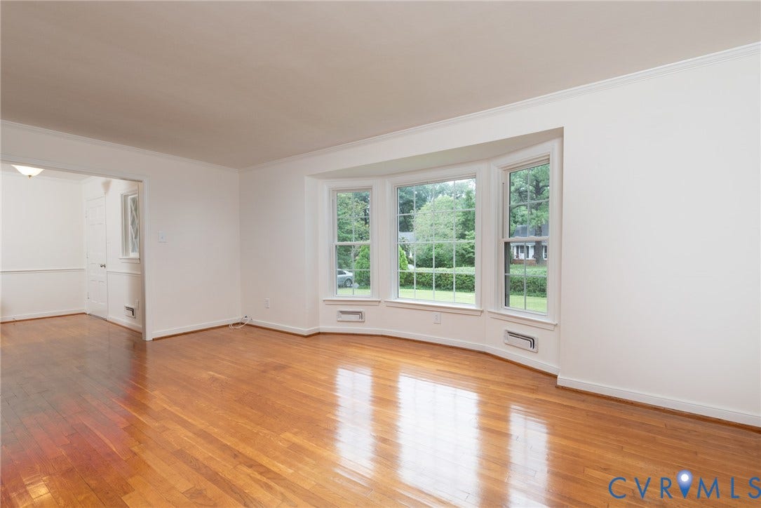 2519 Woodmont Drive, Woodmont, Chesterfield, VA 23235 Spacious interior featuring a large bay window, polished wood-finish flooring, white walls, and elegant crown molding