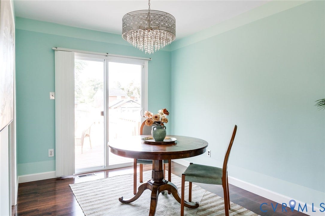 Lovely dining room with mid century chandelier and sliding glass doors to the back deck.