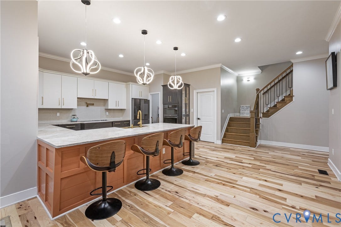 12554 Kain Road, Glen Allen, VA 23059 Kitchen featuring a large island with paneling, white upper cabinetry, and a tile backsplash