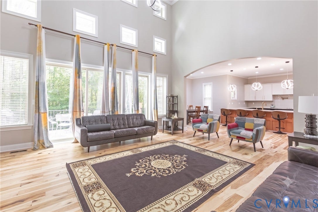 12554 Kain Road, Glen Allen, VA 23059 Two-story living area with wood-finish flooring, abundant natural light, and an arched entry to the kitchen