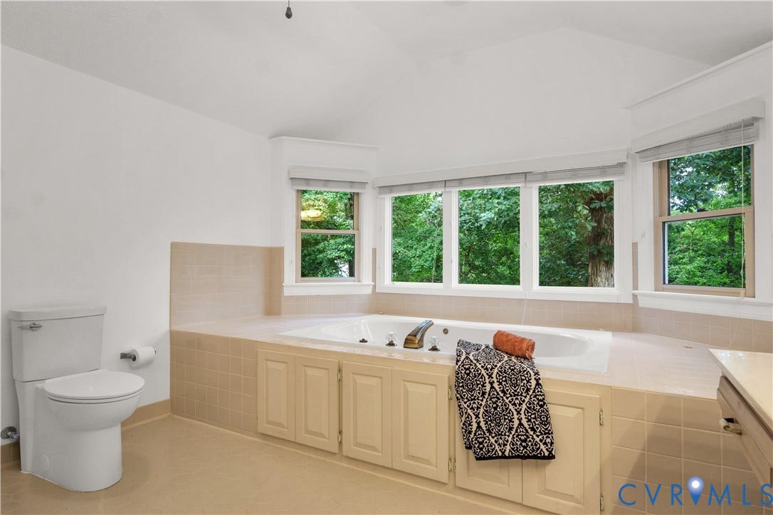 3005 Heritage Landing Road, Heritage Landing, Williamsburg, VA 23185 Elegant primary bath with double vanity, walk-in shower, and jetted soaking tub facing peaceful woods