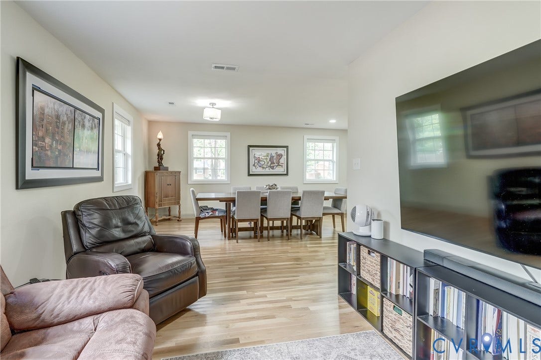 Light wood-finish flooring extends throughout, complemented by recessed lighting and multiple windows