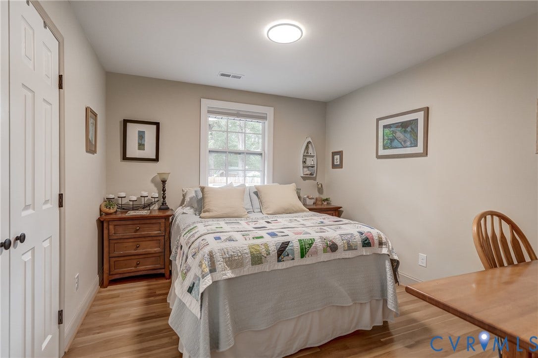 Hardwood-finish flooring, recessed lighting, and a white-trim window