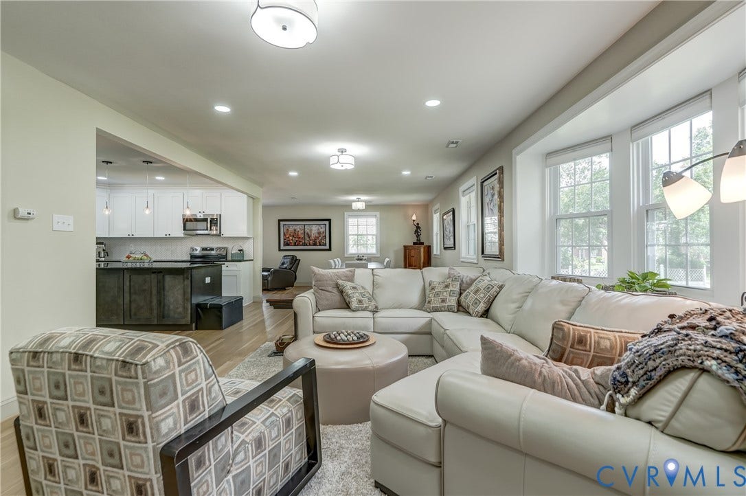 Spacious living area featuring recessed lighting, a large bay window, and light wood-finish flooring