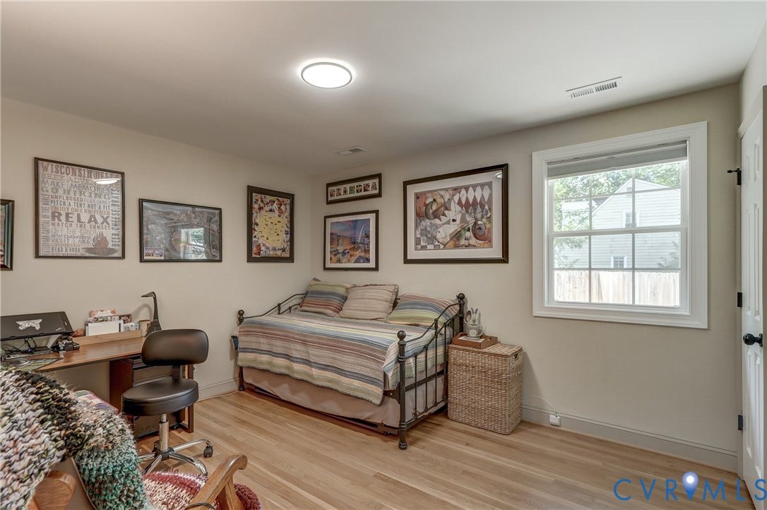 Wood-finish flooring, single window, recessed lighting, and a white door with black hardware