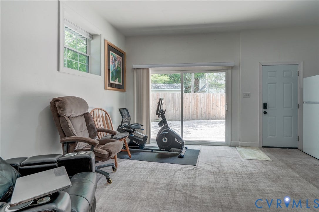 Hard surface flooring, sliding glass door, white paneled door, window, and light neutral wall paint