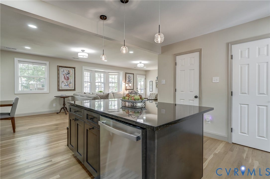 Kitchen island with dark cabinetry and a dark stone countertop