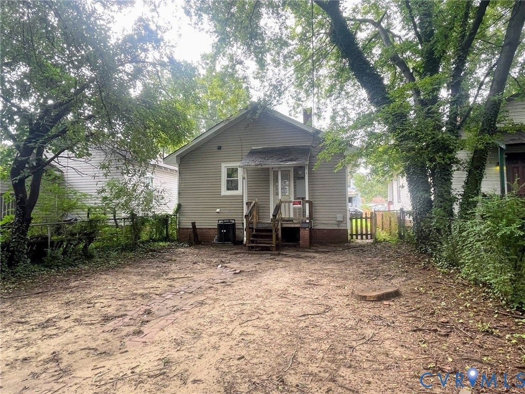 Rear exterior featuring horizontal siding and an entry door