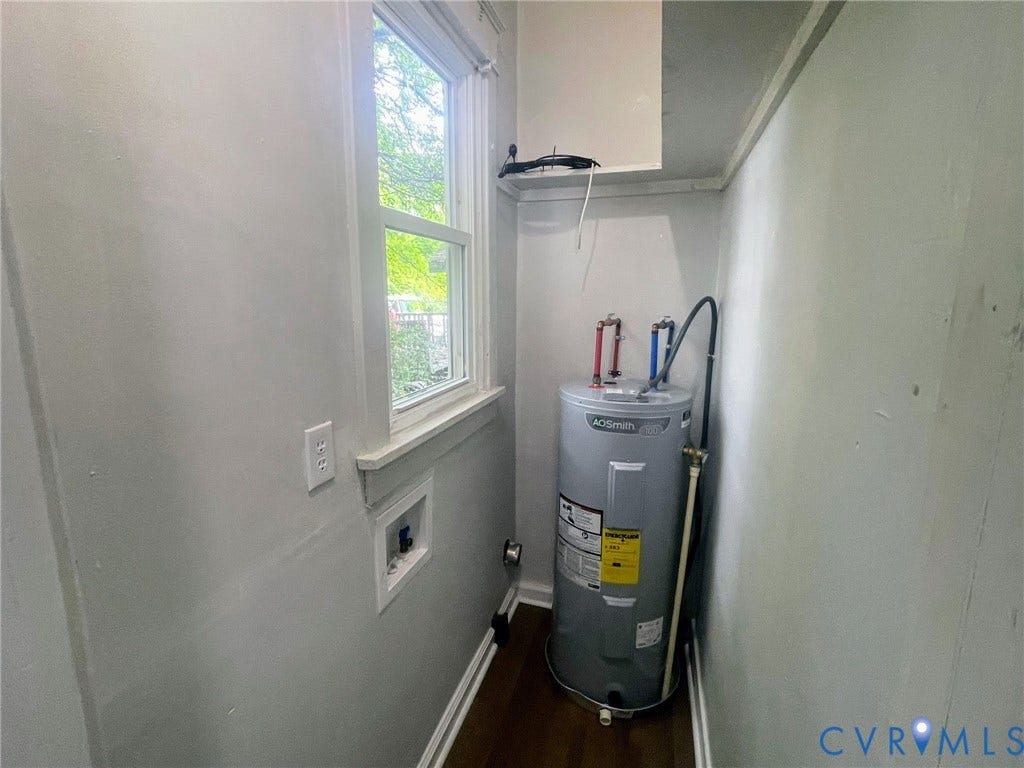 Dedicated utility space featuring a water heater, laundry hookups, and a window for ambient light