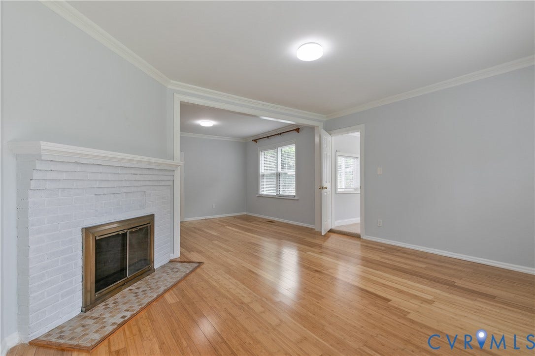 4809 Penick Road, Brookland, Henrico, VA 23228 Living area featuring wood-finish flooring, a painted brick fireplace with a brass firebox, crown molding, and light gray wall paint