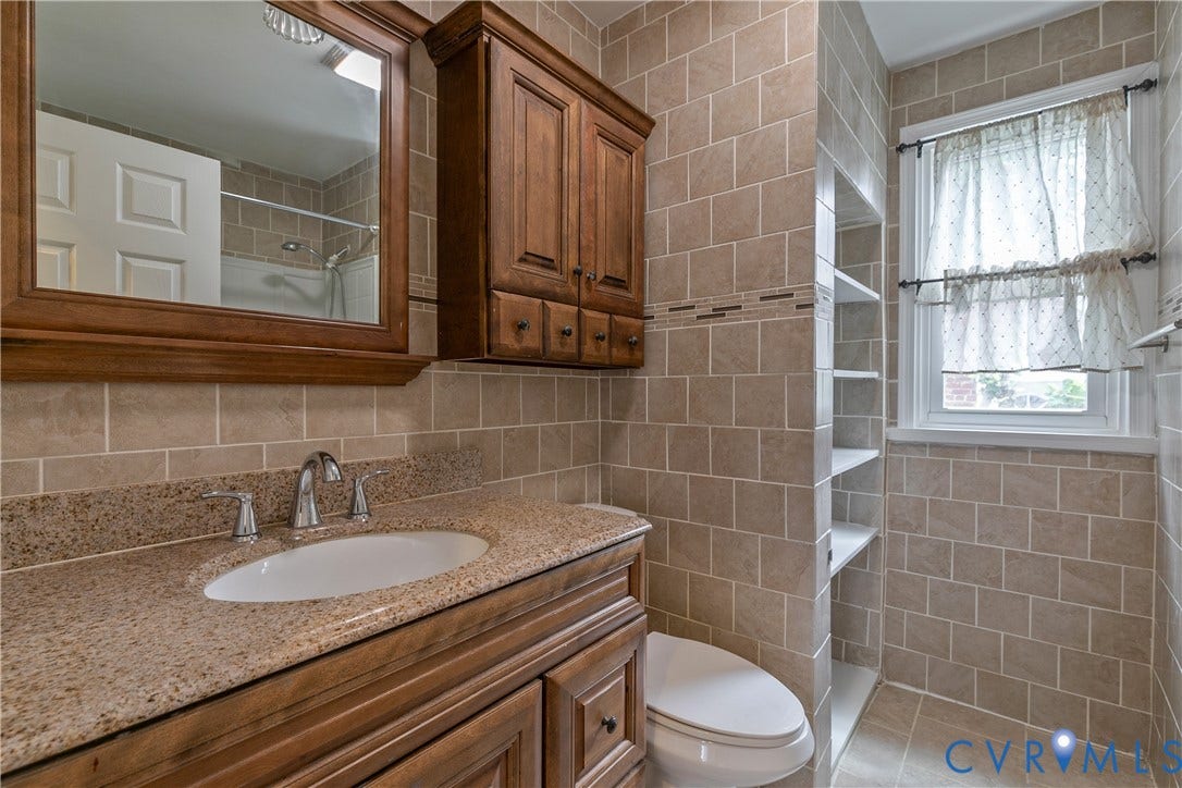 4809 Penick Road, Brookland, Henrico, VA 23228 Bathroom featuring a wood vanity with a stone countertop, an undermount sink, and a framed medicine cabinet