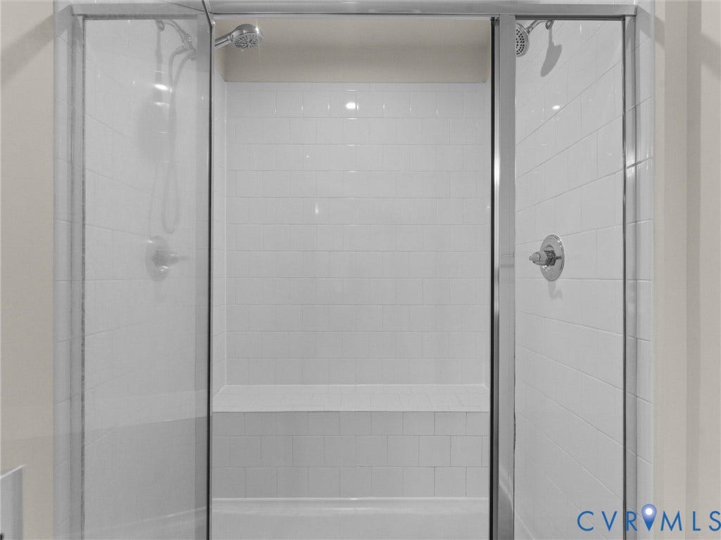 12601 Prestonfield Drive, Blalock, Chesterfield, VA 23836 Glass-enclosed shower with white subway tile, built-in bench, and dual shower heads with chrome fixtures