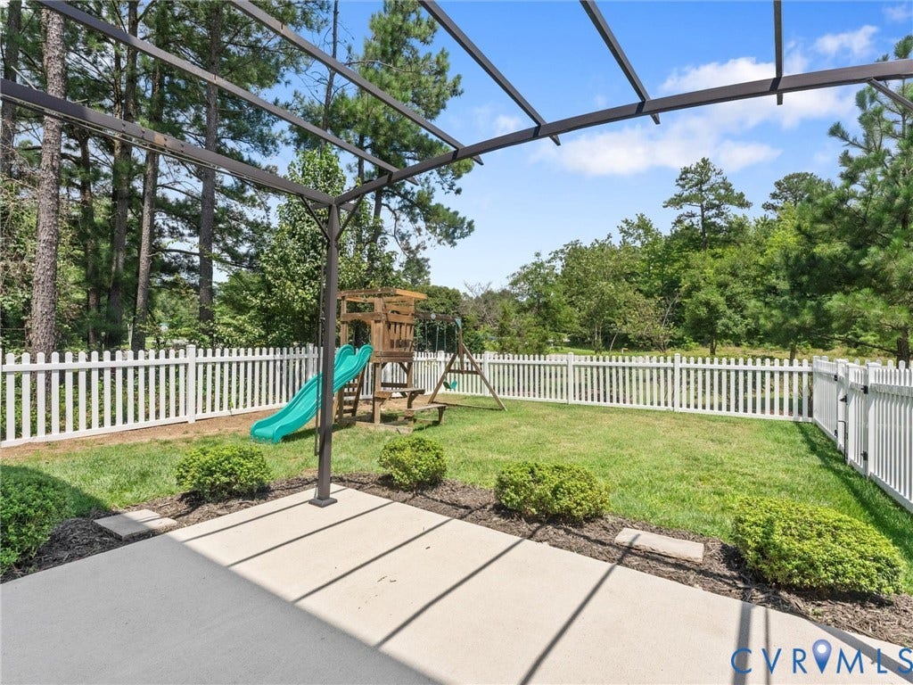 12601 Prestonfield Drive, Blalock, Chesterfield, VA 23836 Private backyard featuring a concrete patio, metal pergola, white picket fence, and a manicured lawn