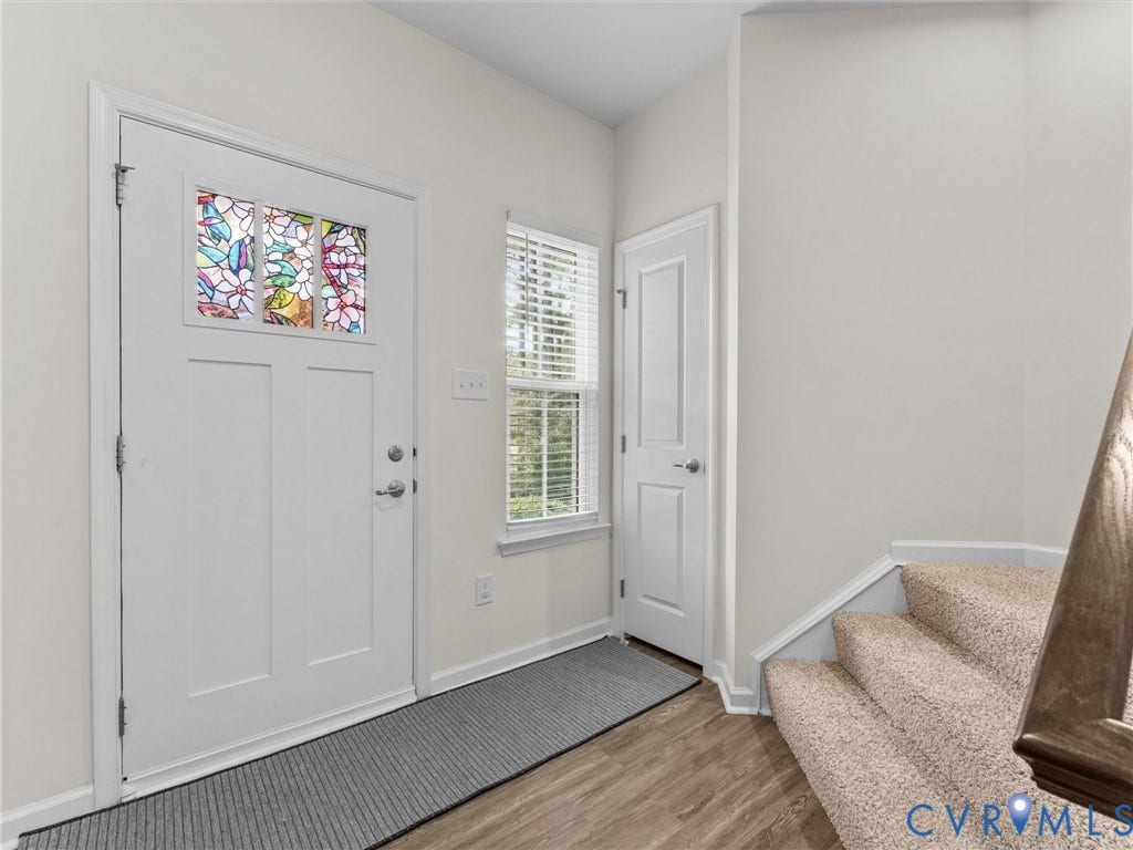 12601 Prestonfield Drive, Blalock, Chesterfield, VA 23836 Entryway featuring wood-finish flooring, a front door with decorative glass, a side window with blinds, and a carpeted staircase