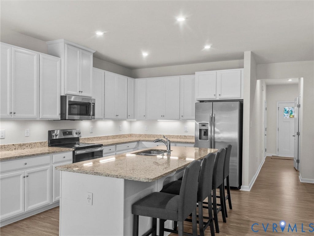 12601 Prestonfield Drive, Blalock, Chesterfield, VA 23836 Kitchen featuring white cabinetry, stainless steel appliances, recessed lighting, wood-finish flooring, and a central island with a sink and seating