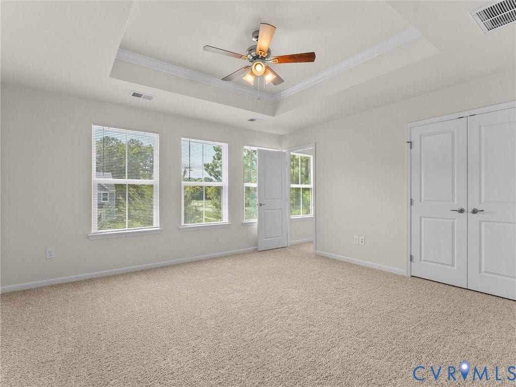 12601 Prestonfield Drive, Blalock, Chesterfield, VA 23836 Tray ceiling with crown molding and ceiling fan, neutral carpet flooring, multiple windows, and paneled doors