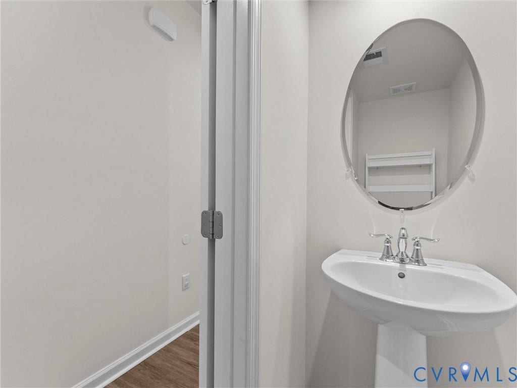 12601 Prestonfield Drive, Blalock, Chesterfield, VA 23836 Pedestal sink with chrome faucet, oval mirror, and light-toned walls