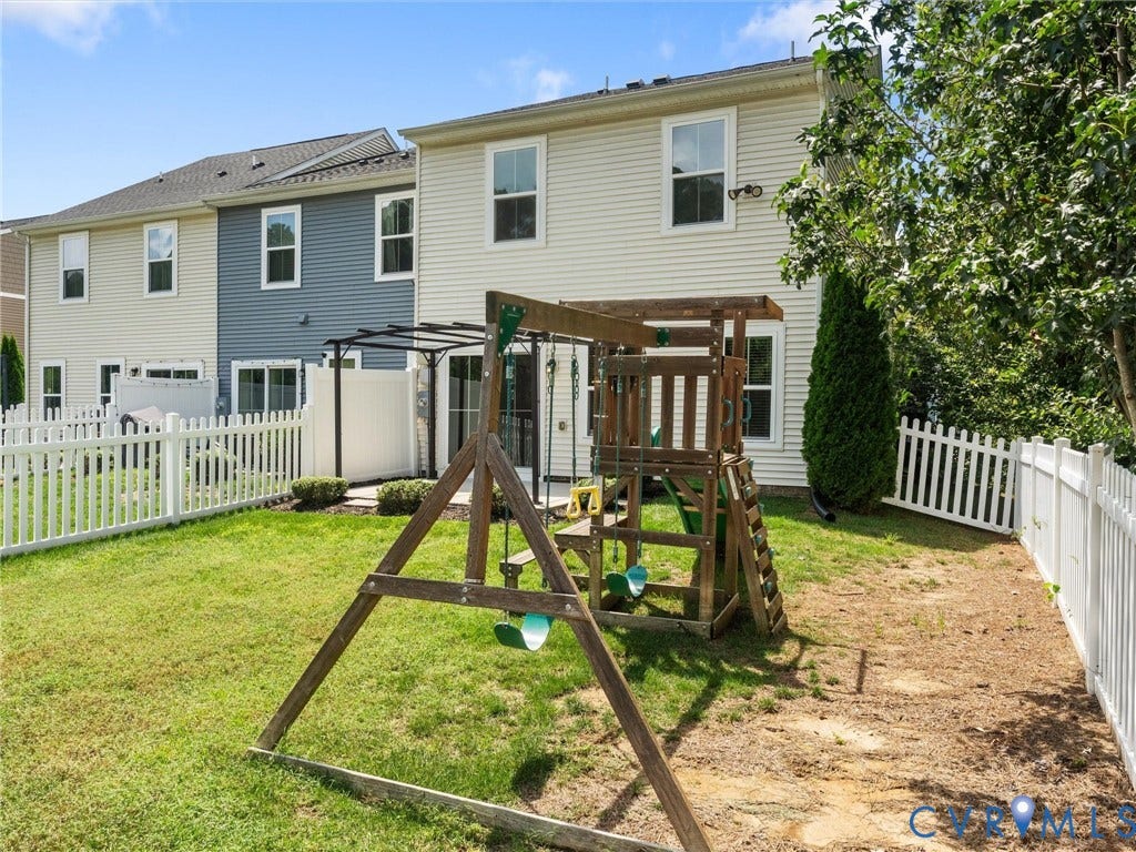 12601 Prestonfield Drive, Blalock, Chesterfield, VA 23836 Backyard featuring a white picket fence, mature trees, and a ground-level patio with a pergola