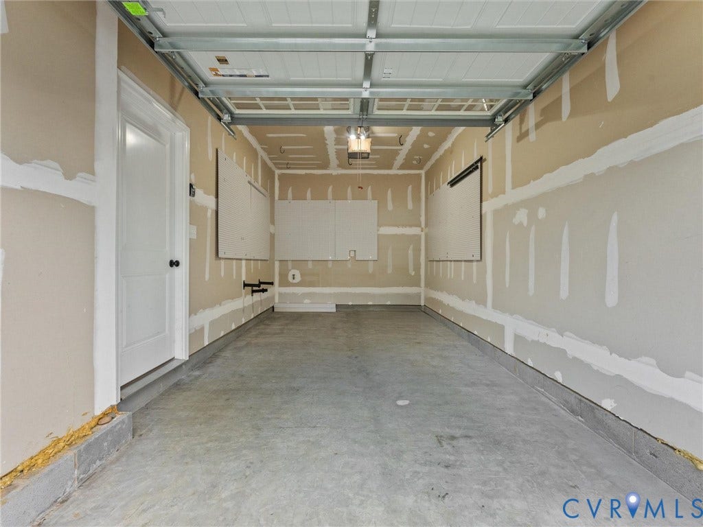 12601 Prestonfield Drive, Blalock, Chesterfield, VA 23836 Concrete flooring, garage door track system, overhead lighting fixture, and interior door with dark hardware