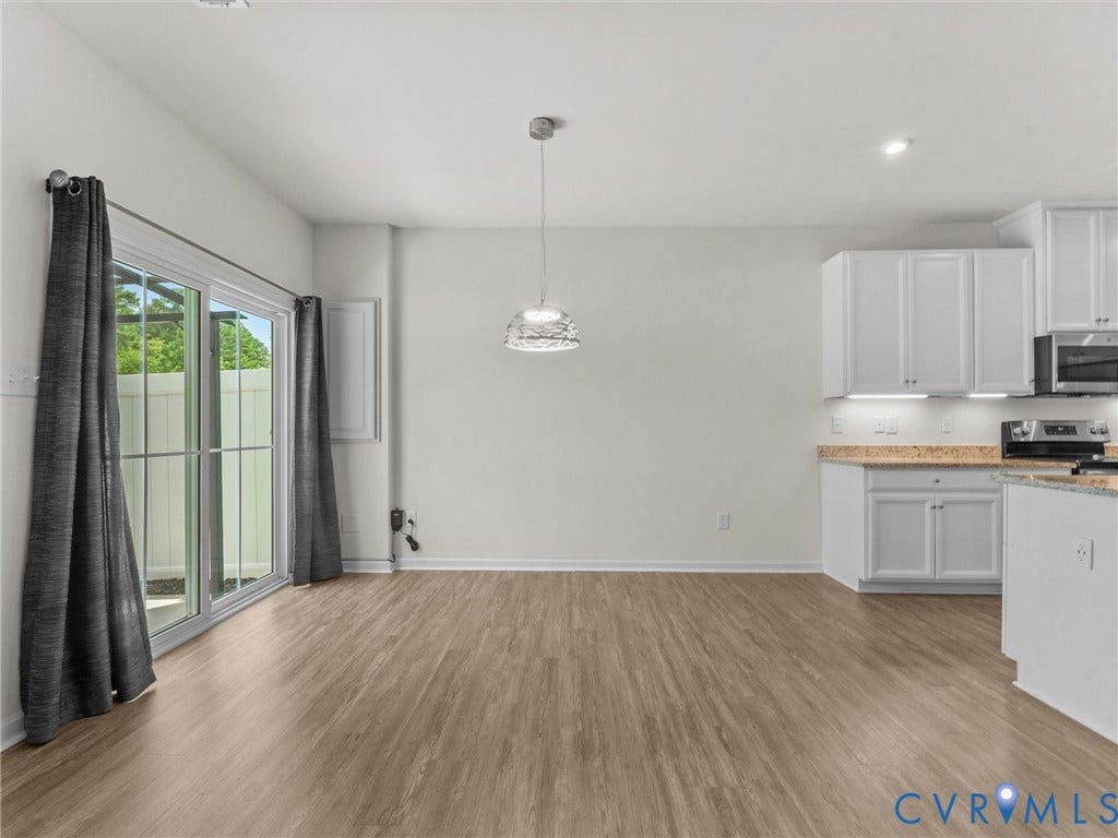 12601 Prestonfield Drive, Blalock, Chesterfield, VA 23836 Open concept space featuring light wood-finish flooring, white cabinetry, and a modern pendant light fixture
