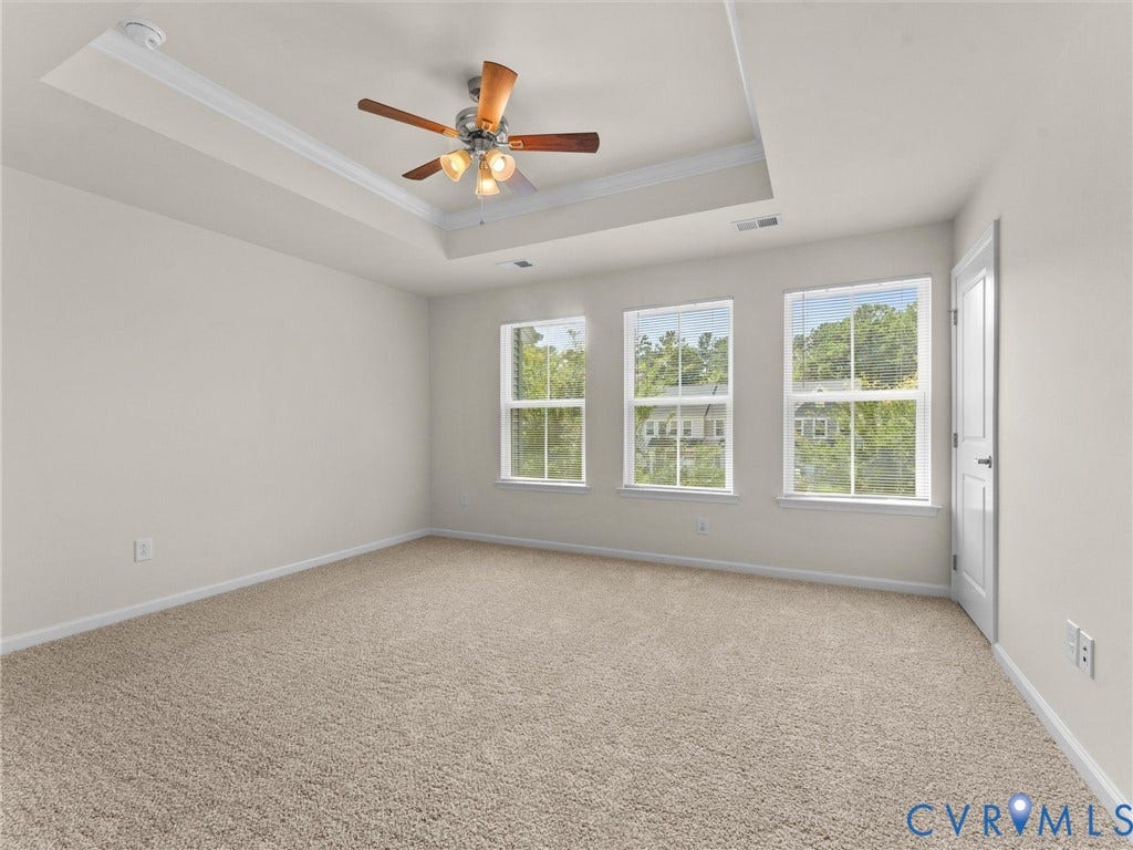 12601 Prestonfield Drive, Blalock, Chesterfield, VA 23836 Tray ceiling with crown molding, ceiling fan with integrated lighting, three windows, neutral-toned wall paint, and plush carpeting
